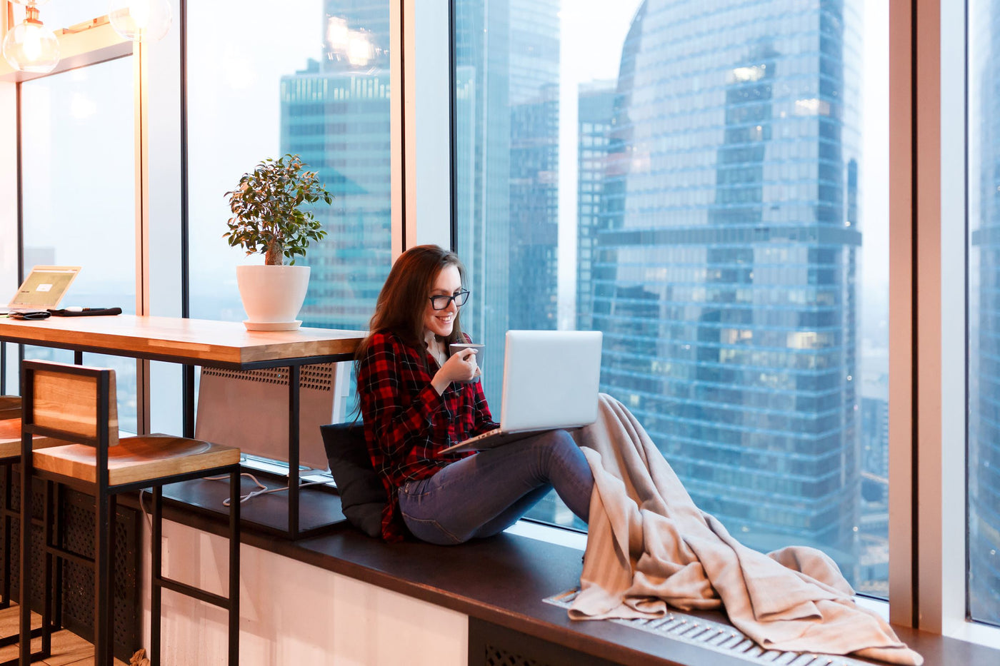 Woman working from home with a blanket.